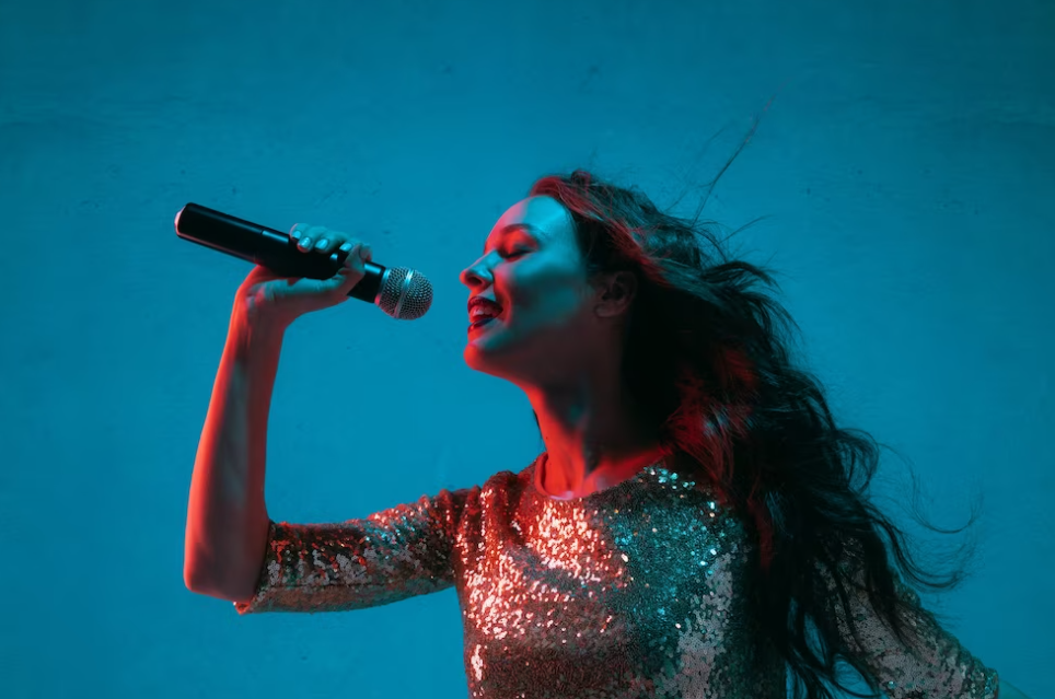 woman dressed in shiny dress holding microphone and singing